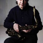 Jan Garbarek_seating_with_horn Ph Guri Dahl